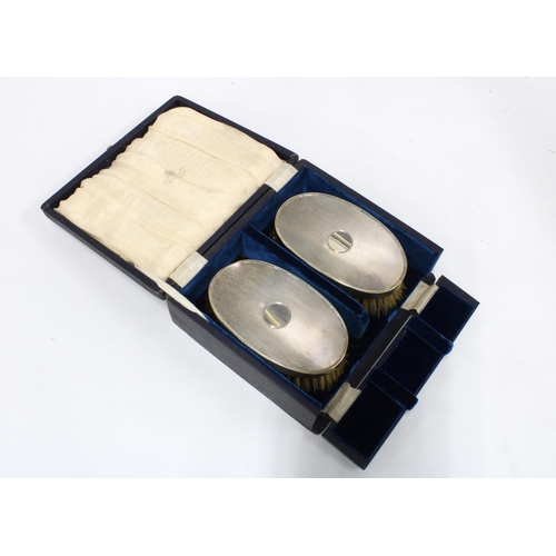 27 - A pair of Gents silver backed brushes, cased, London 1945 (2)