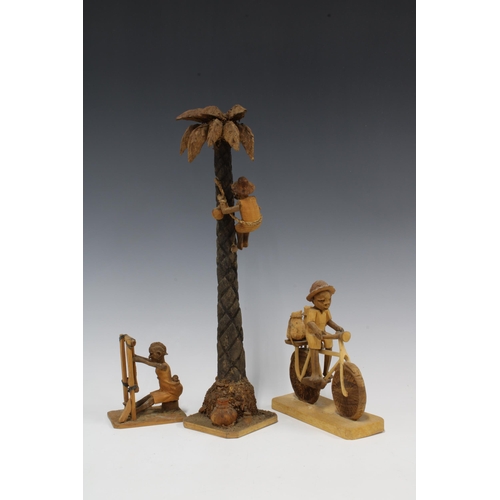 316 - A collection of Nigerian carved wood figure groups to include a boy climbing a palm tree, another on... 