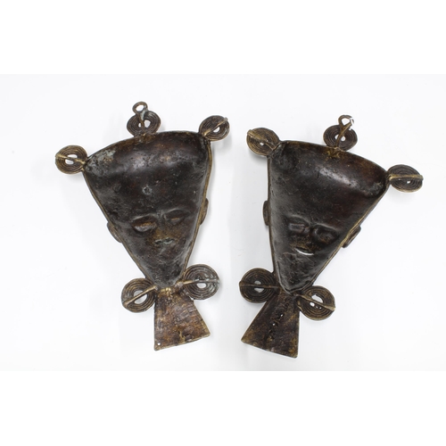 317 - A pair of African bronze wall masks with three ringlets over a triangular face with pointed beard, 3... 