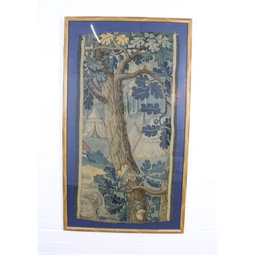 404 - An Antique tapestry showing a camp in a forest, framed under glass, 112 x 60cm