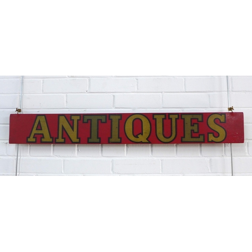 449 - Handpainted red gilt 'Antiques' sign, 105 x 14cm.