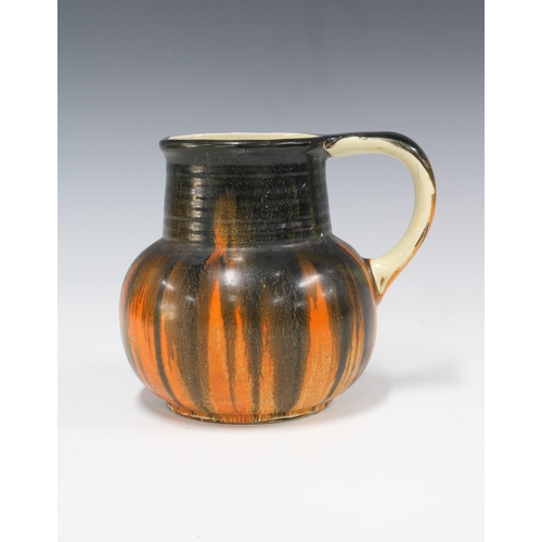 87 - Early 20th century Trent pottery jug with orange and black drip pattern, 16 x 18cm.