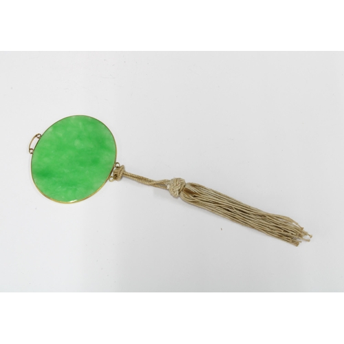 150 - Green jade plaque pendant in an unmarked yellow metal mount with thread tassel, 5.5cm wide