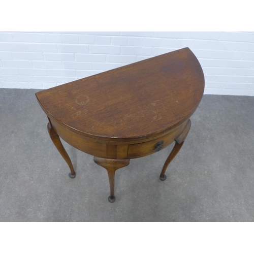 226 - An oak demi-lune foldover card table, 77 x77 x 38cm.