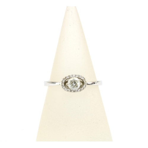 23 - 18ct white gold diamond ring with a claw set bright cut diamond within a surround of smaller diamond... 