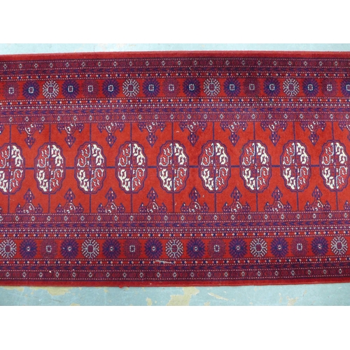 253 - Bokhara style runner with red field and seventeen guls, 350 x 90cm.