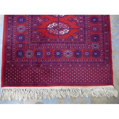 253 - Bokhara style runner with red field and seventeen guls, 350 x 90cm.