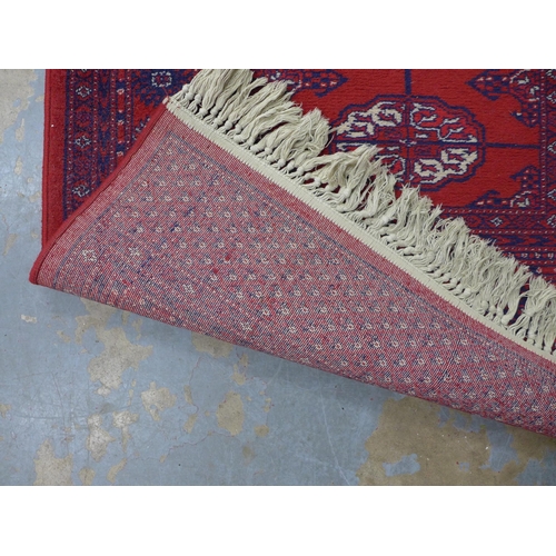 253 - Bokhara style runner with red field and seventeen guls, 350 x 90cm.