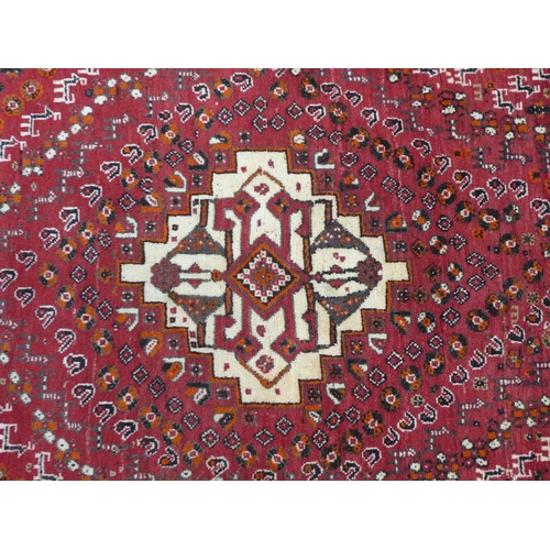 255 - Quashqai rug, red field with central ivory medallion, labelled Kashgai 150 x 167cm.