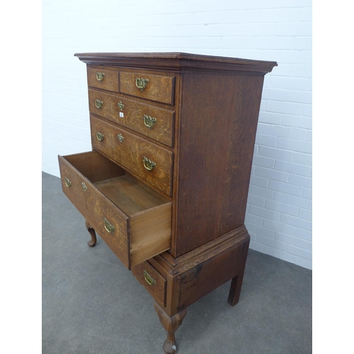 286 - An oak chest on stand, the top with two short and three graduating long drawers, the base with three... 