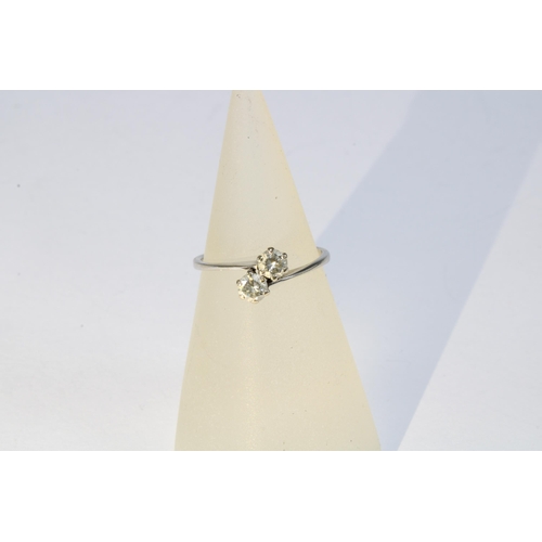 31 - Diamond two stone crossover ring, set in an unmarked white metal band, size J.