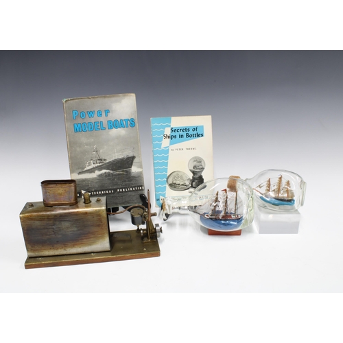 399 - Two model ships in bottles, together with a model boat steam engine and the books 'Secrets of Ships ... 