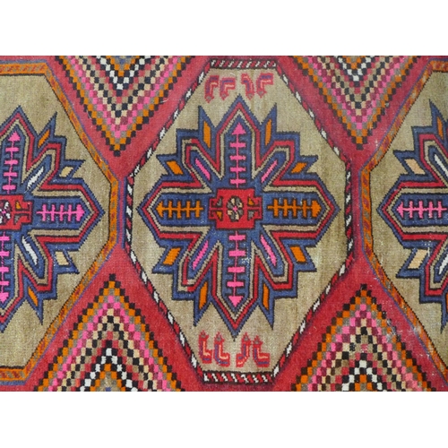 404 - Kazak style rug, red field with three flowerhead medallions, 192 x 132cm.