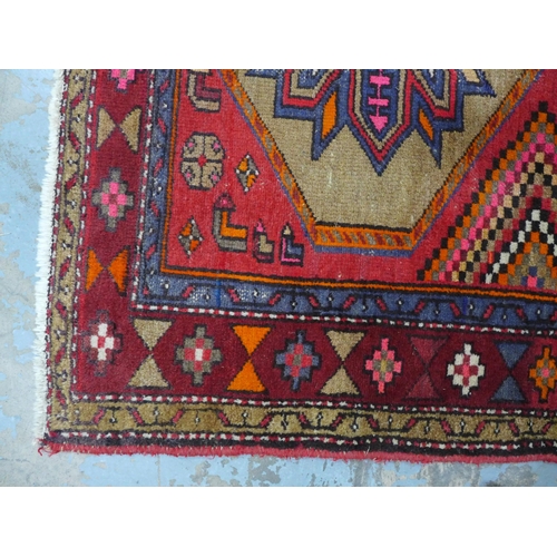 404 - Kazak style rug, red field with three flowerhead medallions, 192 x 132cm.