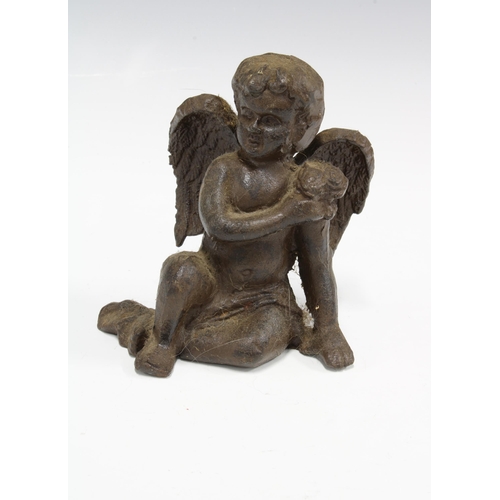 414 - Bronze patinated metal figure of a seated cherub, 13cm