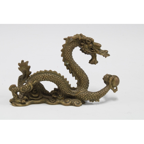 422 - A bronze dragon and pearl of wisdom figure, 12cm long