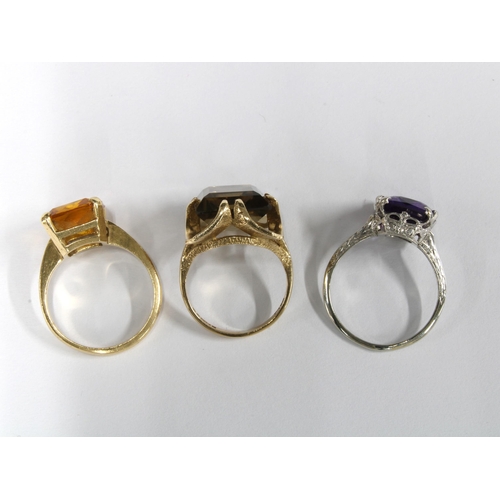 55 - 9ct gold smoky quartz ring, 14ct gold citrine ring and a white metal gemset dress ring with indistin... 