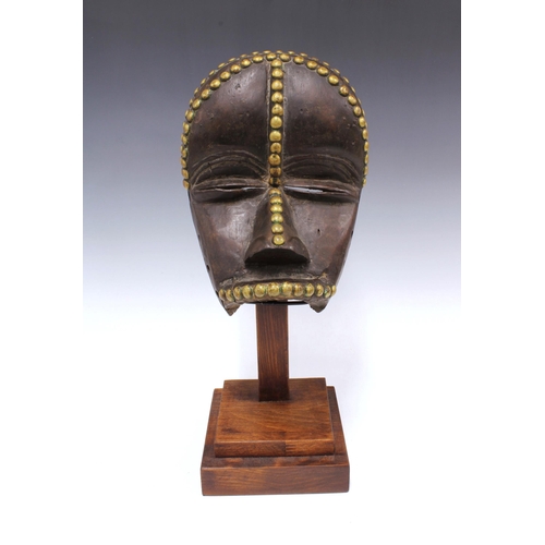 305 - Dan Mask, Liberia, wooden with brass studwork, on a display plinth, 26cm.  Private collection, Franc... 