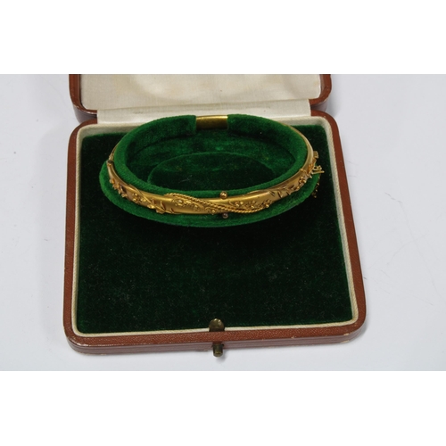 73 - Victorian 15ct gold bangle with applied floral pattern, in fitted box, stamped 15ct