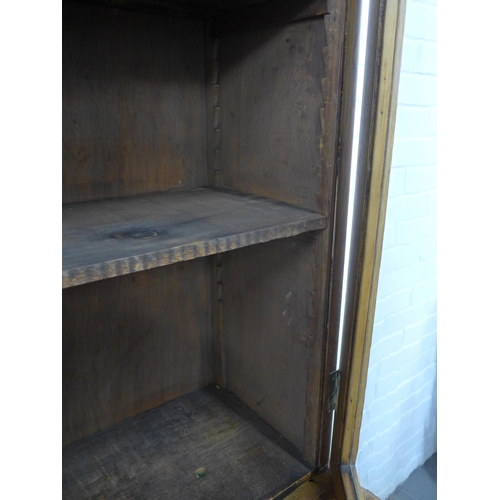 290 - An oak bookcase cabinet, projecting cornice above three glazed doors with a shelved interior, over t... 