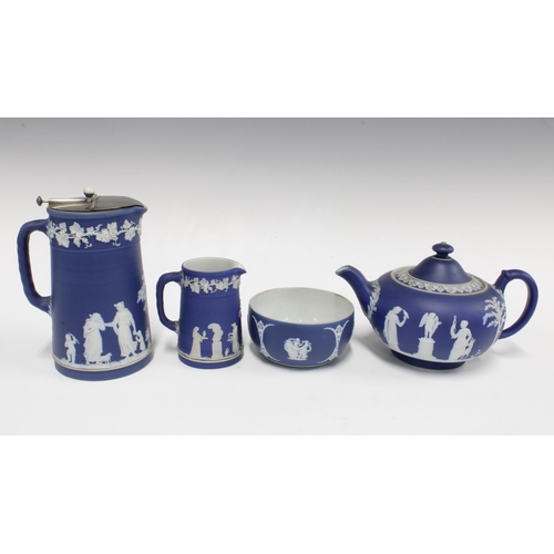 142 - Wedgwood blue and white Jasperware to include a teapot, cream jug, sugar bowl and hot milk jug (4)