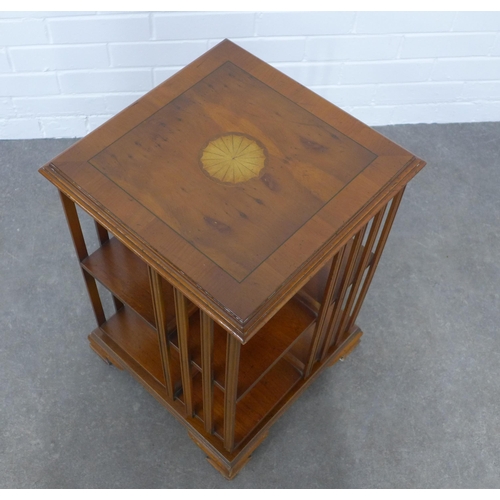 206 - Yew wood revolving bookcase of small proportions, the square top with a satinwood paterea, 40 x 60cm... 