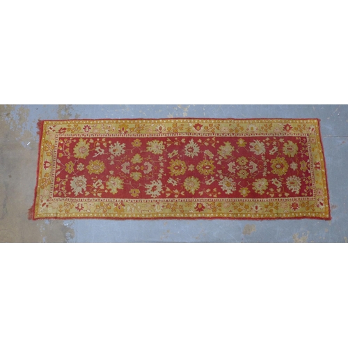 249 - Ushak runner, red field with foliate pattern within an orange border, 265 x 95cm.