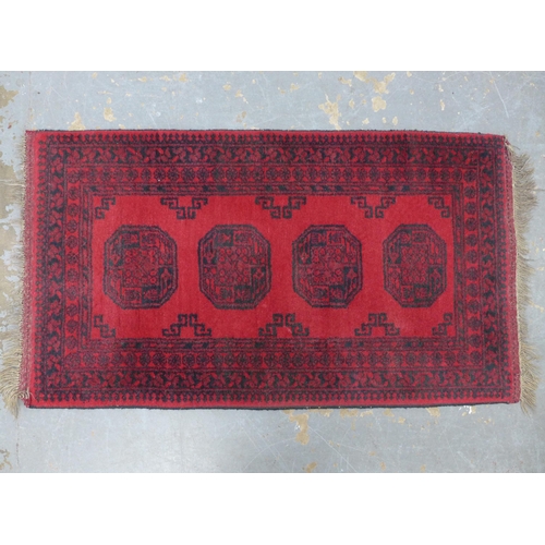 251 - Afghan rug, red field with four guls,  140 x 76cm.