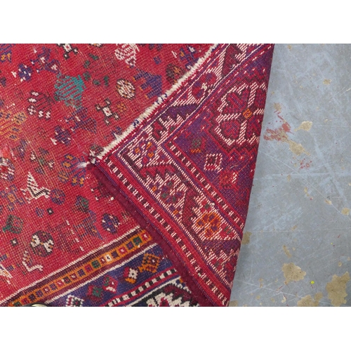 264 - Turkish rug with a worn red field, central hooked medallion with figures and camels,  166 x 112cm.