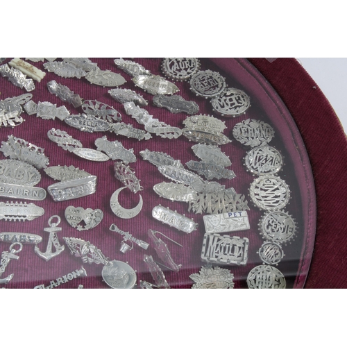 81 - A large collection of Victorian silver name brooches, contained within a circular glazed top showcas... 