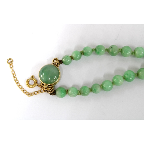 9 - 15ct gold carved jade and seed pearl brooch, 9ct gold jade cabochon ring and a strand of jade beads ... 