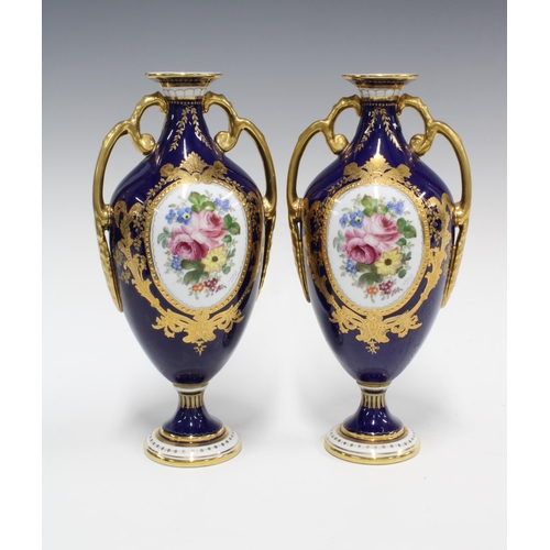 90 - Pair of Royal Crown Derby urn vases, blue ground and floral decorated panels, printed factory marks ... 