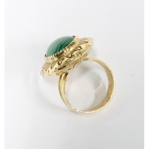 18 - Polished malachite cabochon dress ring in an unmarked yellow metal surround on an unmarked band, siz... 