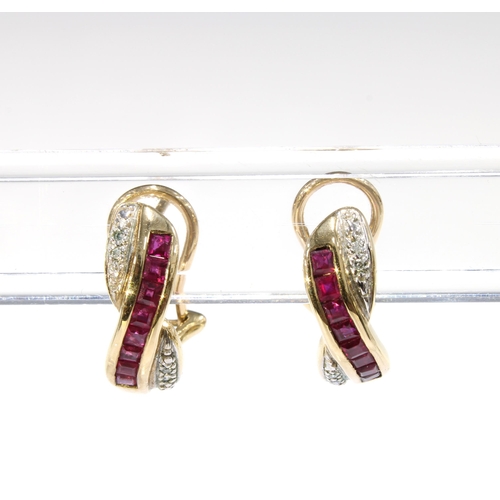 25 - A pair of 9ct gold ruby and diamond earrings with a row of eight calibre cut rubies flanked by white... 