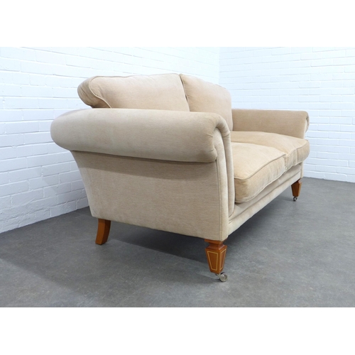 297 - DAVID LINLEY, LONDON, beige upholstered two seater sofa with scroll arms and loose cushion back, rai... 