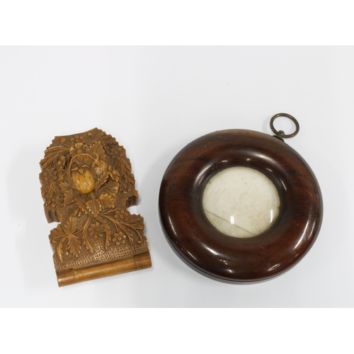 396 - Lime wood pocket watch holder, likely Alpine, 9.5cm, together with a circular mahogany frame, 10cm d... 