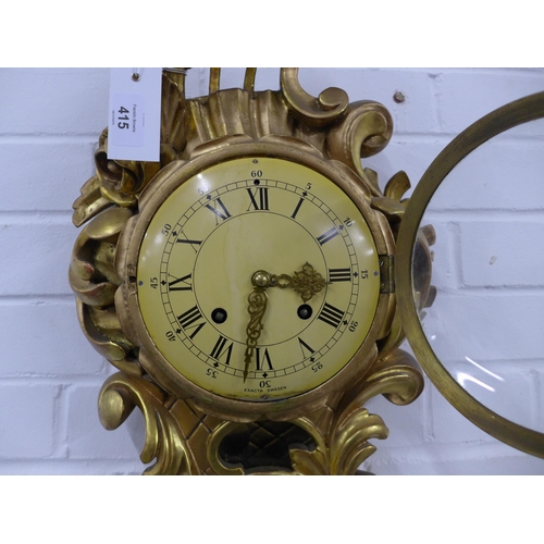 415 - Gilt Cartel wall clock by Exacta of Sweden, 32 x 60cm.