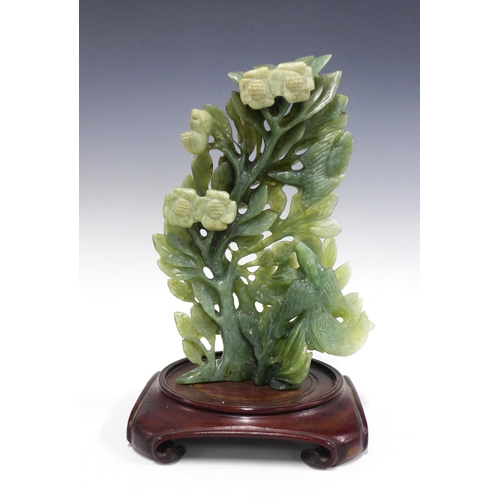 125 - Chinoiserie green jadeite floral carving on a stylised hardwood stand, 21 x 32cm.