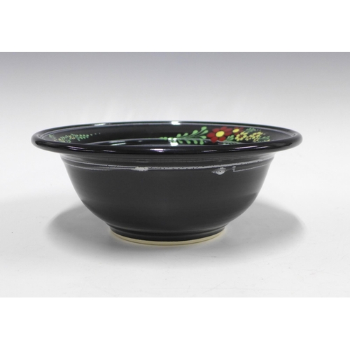 128 - American art pottery bowl, the black glazed ground with flowers in coloured enamels, 25 x 9cm.