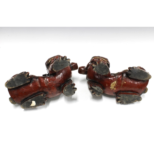 81 - A large pair of  chinoiserie wooden Temple Dogs / Lions with bead eyes (2) 27 x 21cm.