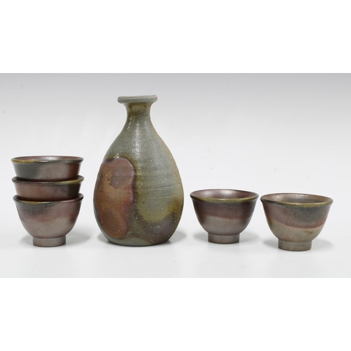 98 - Studio pottery Saki set, ash glazed with impressed monogram, to include a bottle and five cups / bow... 