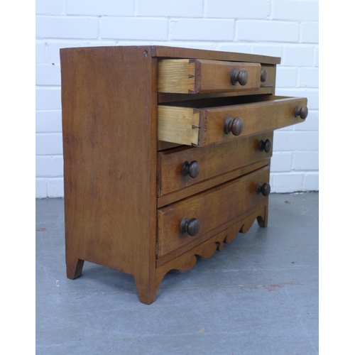 325 - Stained pine apprentice / miniature chest with two short and three graduating long drawers, shaped a... 