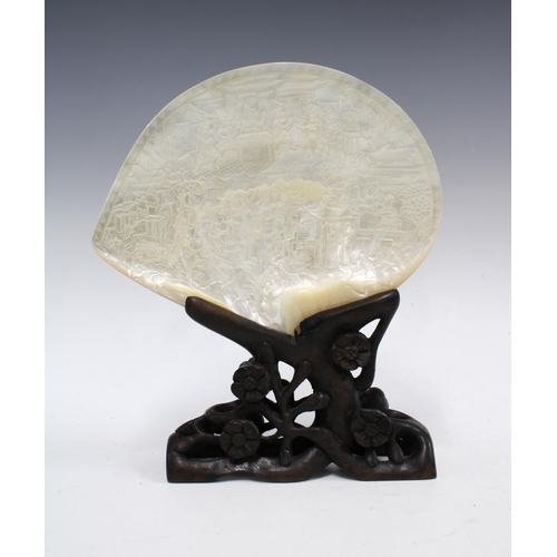 94 - Chinese carved abalone / mother of pearl shell on stylised wooden stand, 24 x 19cm.