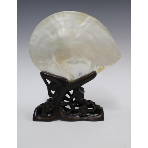 94 - Chinese carved abalone / mother of pearl shell on stylised wooden stand, 24 x 19cm.