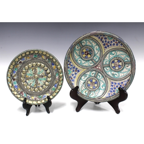 99 - Two Middle Eastern pottery chargers with white metal overlaid borders (2) 26cm.