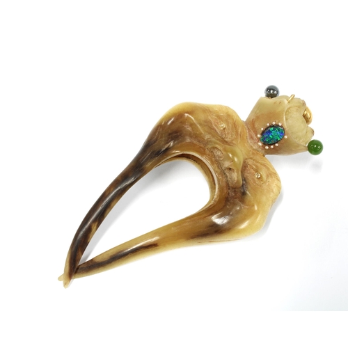 380 - A horn hair comb modelled as a face and jewelled (some jewels lacking) 12cm long