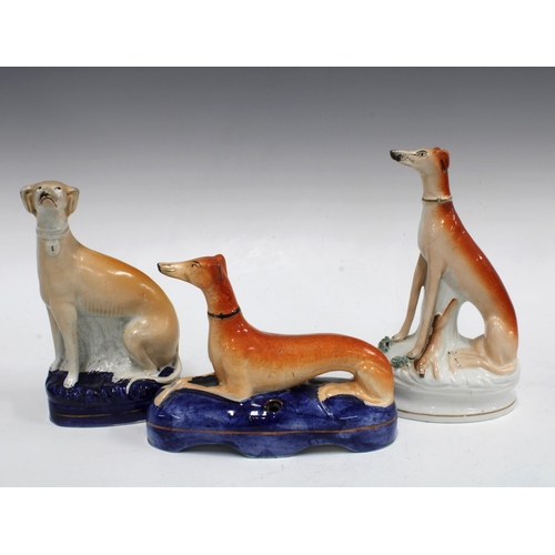 105 - A group of 19th century Staffordshire greyhound figures to include a quill holder, 21cm  (3)