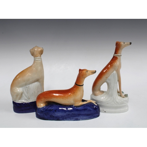 105 - A group of 19th century Staffordshire greyhound figures to include a quill holder, 21cm  (3)