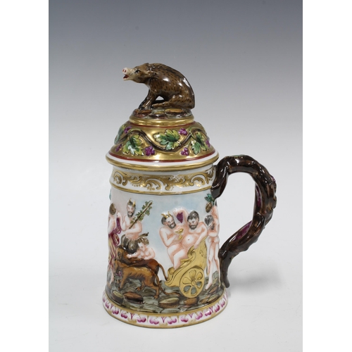 399 - A Capo di Monte tankard decorated in relief with bacchanalian figures, the cover with a boar finial,... 