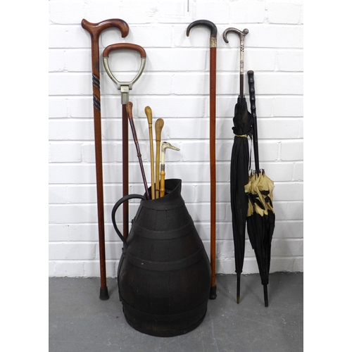 412 - Metal bound wooden jug 49cm, with a vintage umbrella, walking sticks, shooting stick and riding crop... 